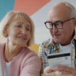 Elderly couple looking at laptop with credit card